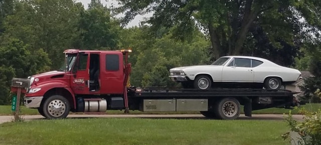 a-classic-white-car-is-being-towed